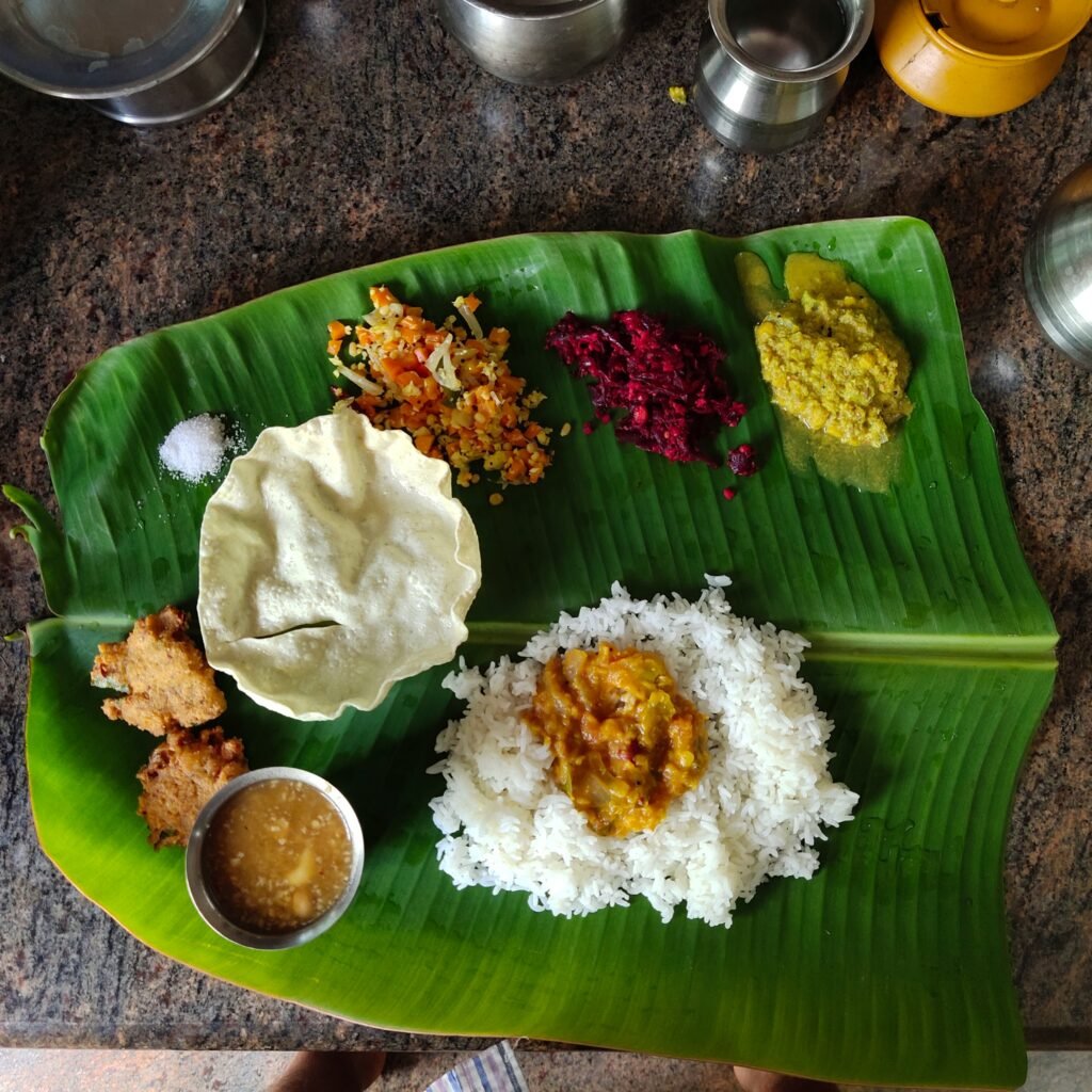 A traditional South Indian meal with various colorful curries, chutneys, and rice.