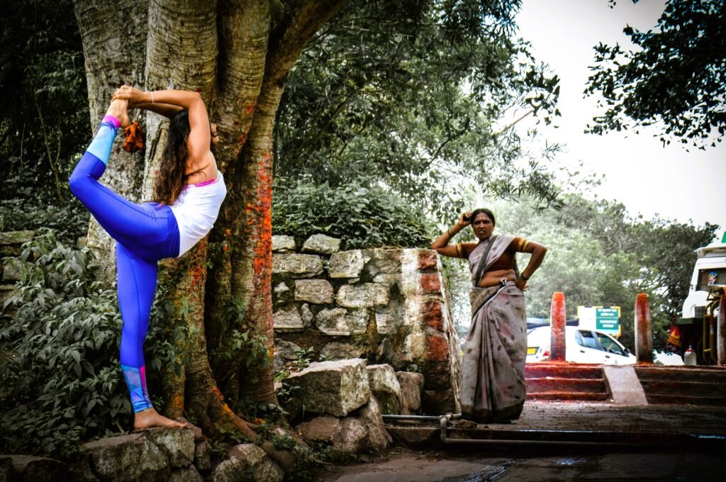 A woman practicing yoga on a busy street in India, surrounded by the hustle and bustle of daily life.